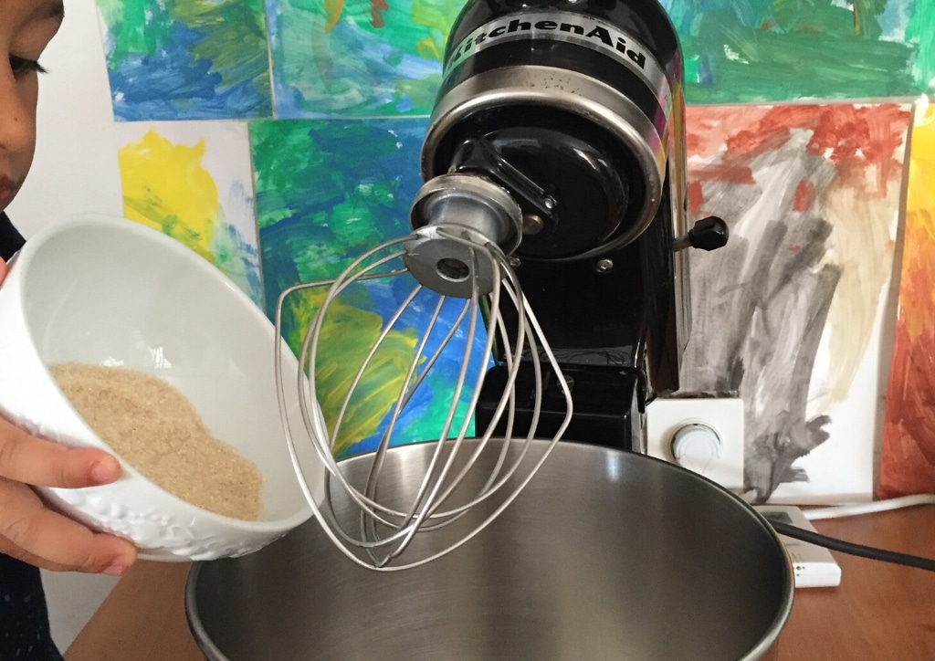 Enfant versant du sucre pour réaliser des cookies aux pépites de chocolat