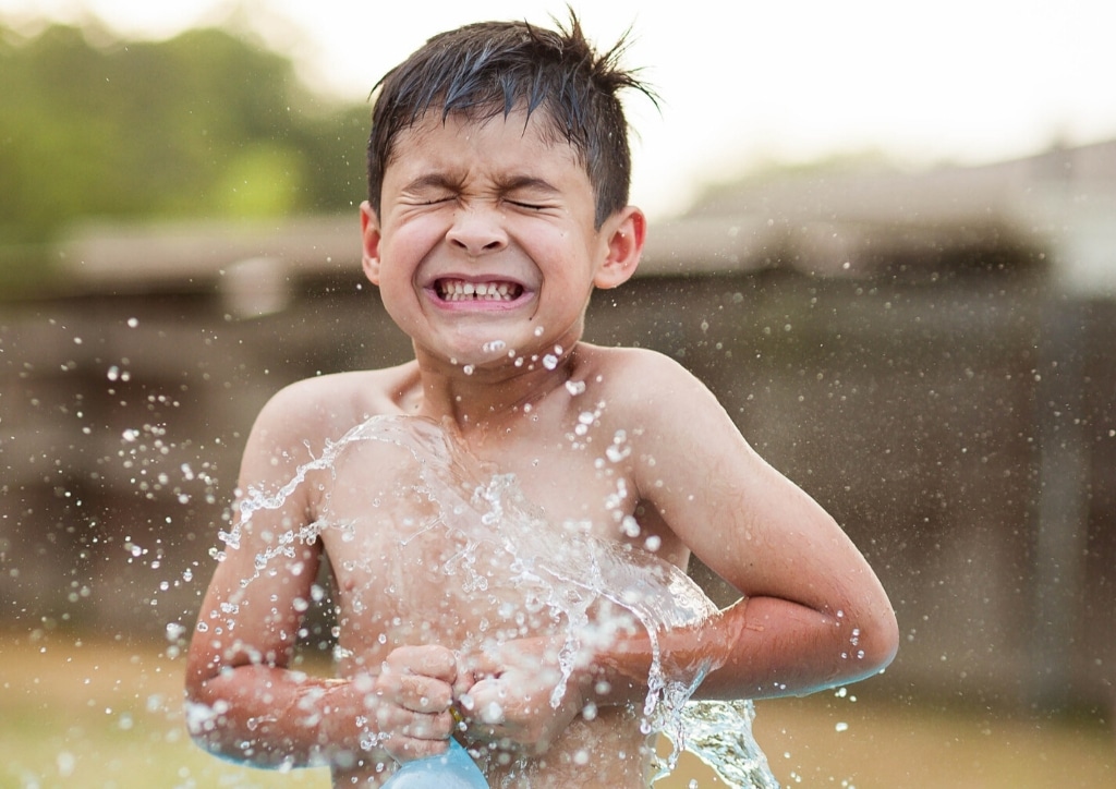Garçon jouant dans l'eau, seul en extérieur.