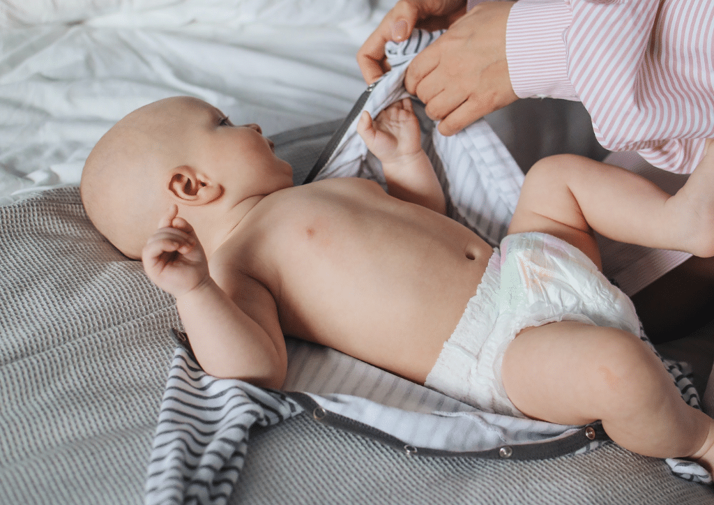 Bébé en train d'être changé avec des couches jetables