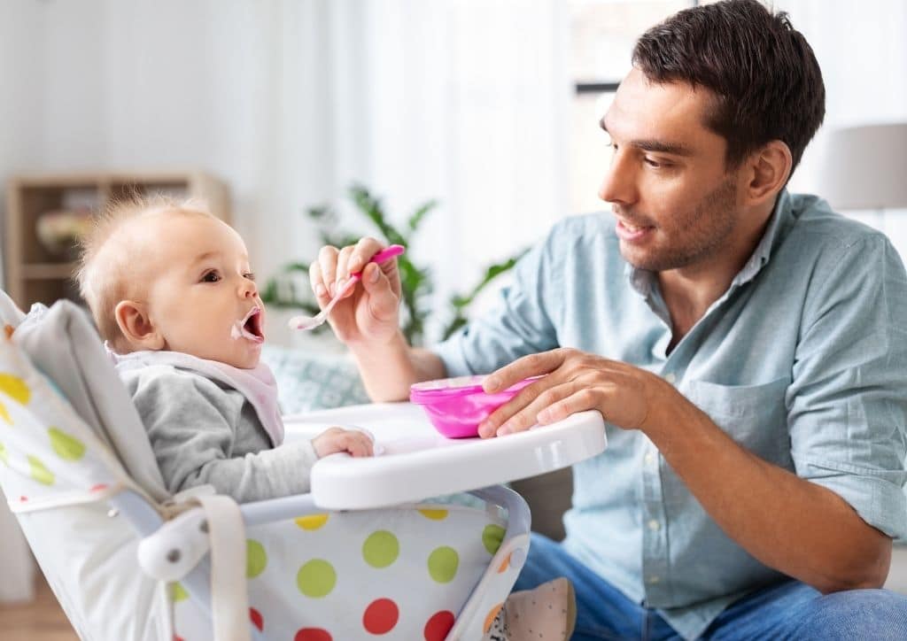 Bébé installé dans une chaise haute pour prendre son repas