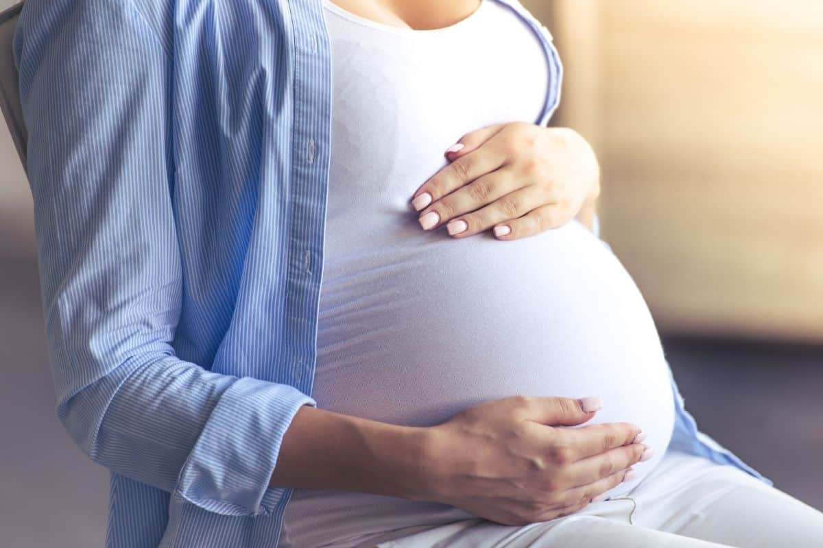 Femme enceinte caressant son ventre