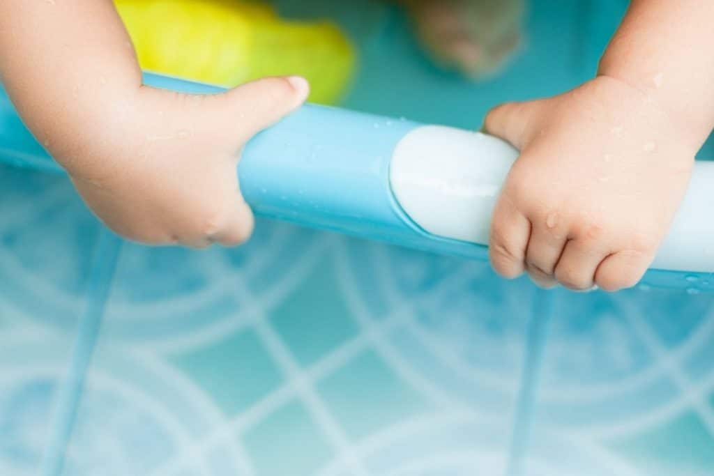 Mains de bébé sur une baignoire bébé