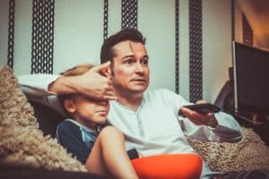 Père cachant un écran à son fils avec sa main