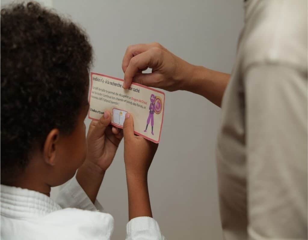 Stan regarde l'étiquette qui lui indique où se situe le 5ème indice de la chasse au trésor ninja