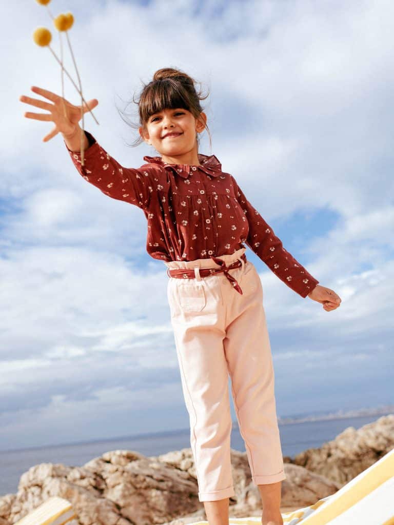 Fillette habillée d'un chemisier et d'un pantalon de la marque Sergent Major