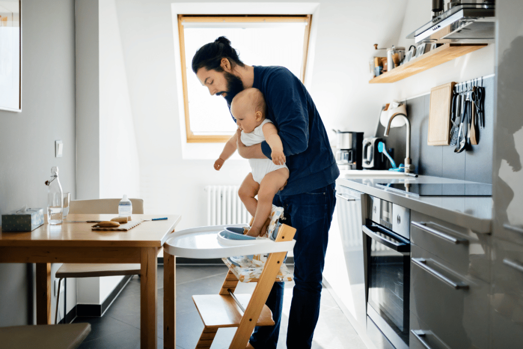 Papa installant son bébé dans une chaise haute