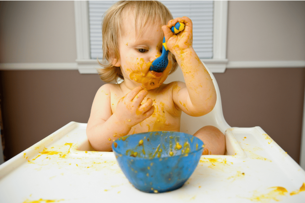Bébé en train de manger dans sa chaise haute