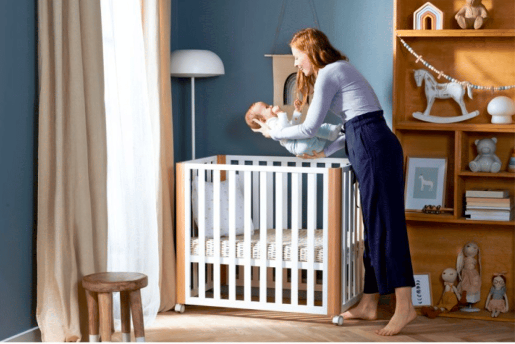 Maman en train de déposer son petit garçon dans son berceau