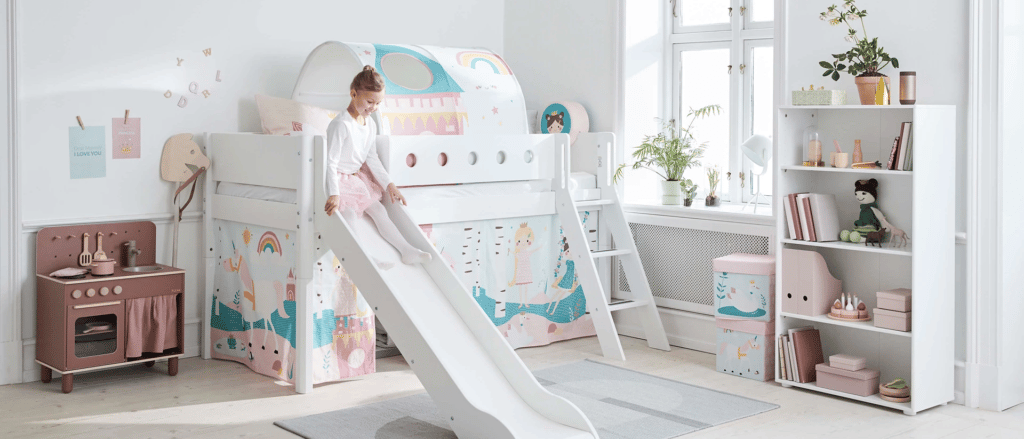 Petite fille sur en train de descendre de son lit par le toboggan