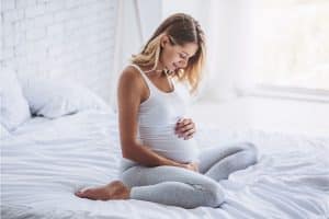 Femme enceinte regardant son ventre avec plaisir