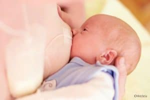 Bébé allaité avec un dispositif d'aide à la lactation