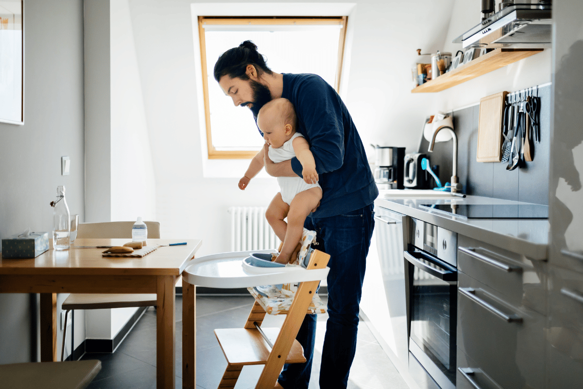 Papa installant son bébé dans une chaise haute