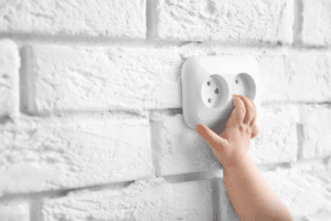 Main de bébé sur une prise électrique
