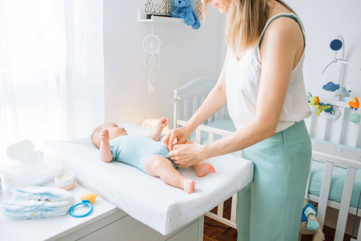 Maman en train de changer bébé sur une table à langer